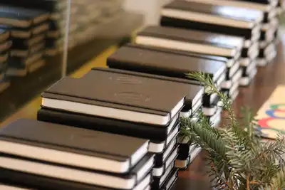 Stacks of black notebooks laid out in rows on a table.