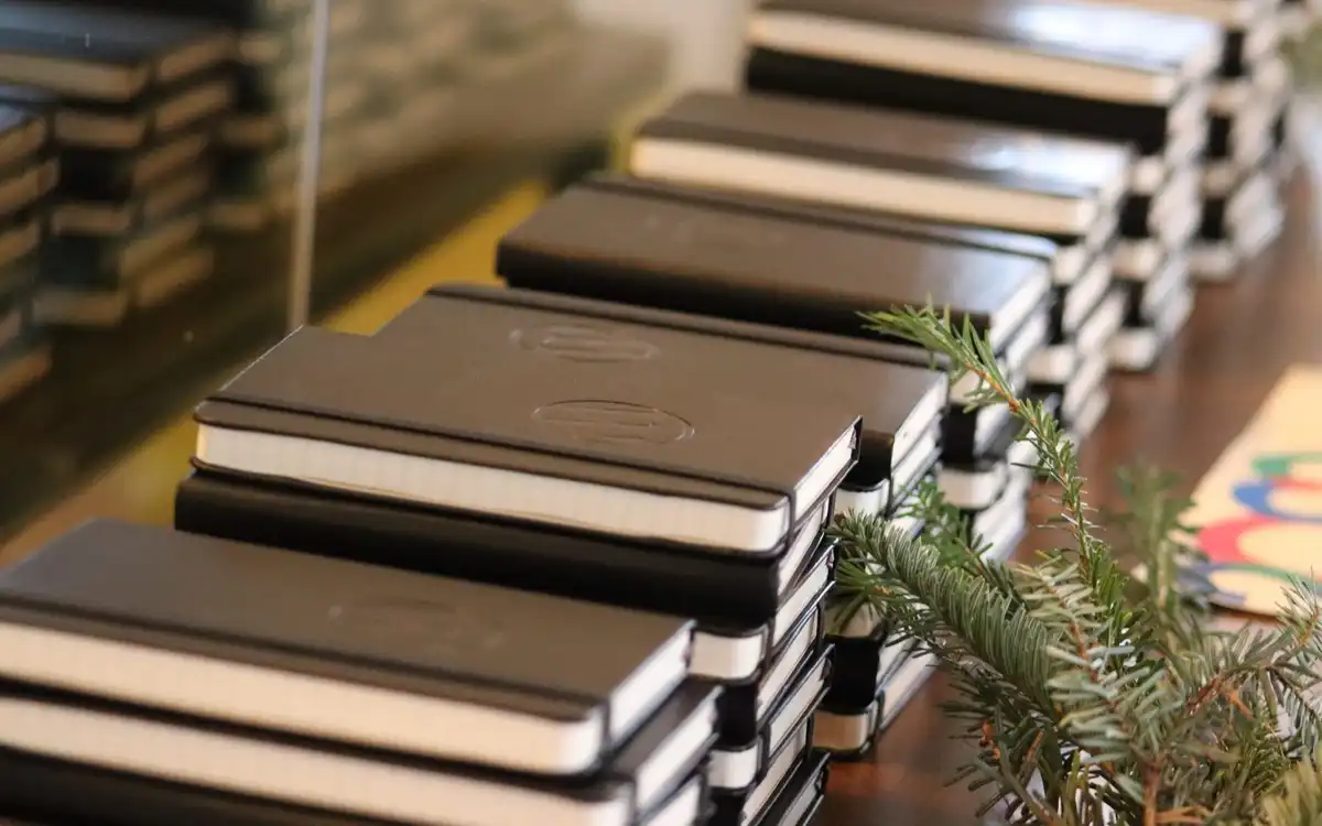 Stacks of black notebooks laid out in rows on a table.