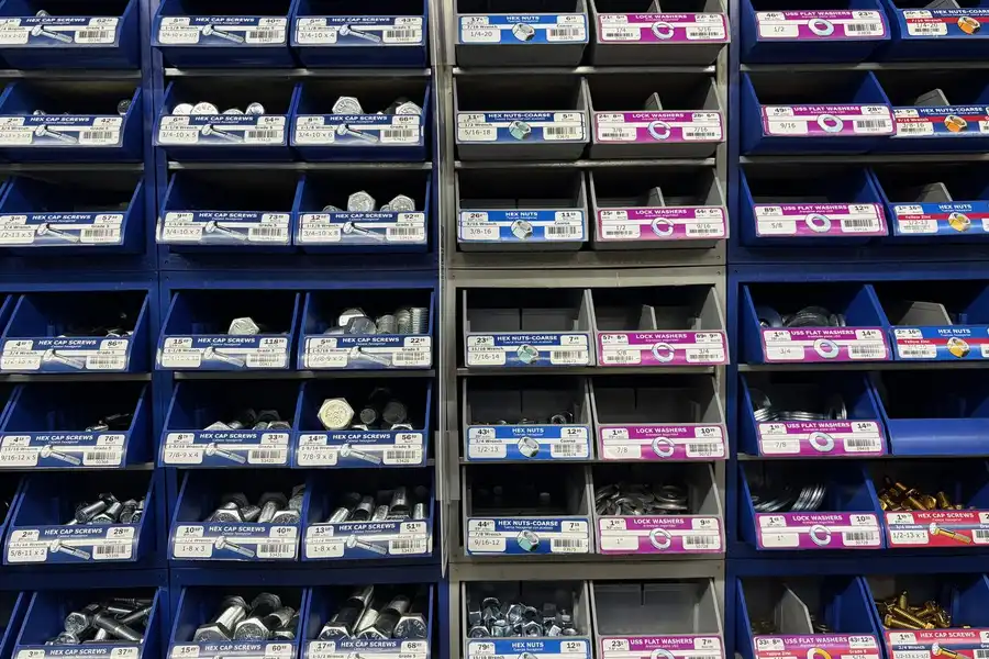 A wall of small blue drawers, each labelled and holding a different size of bolt or screw.